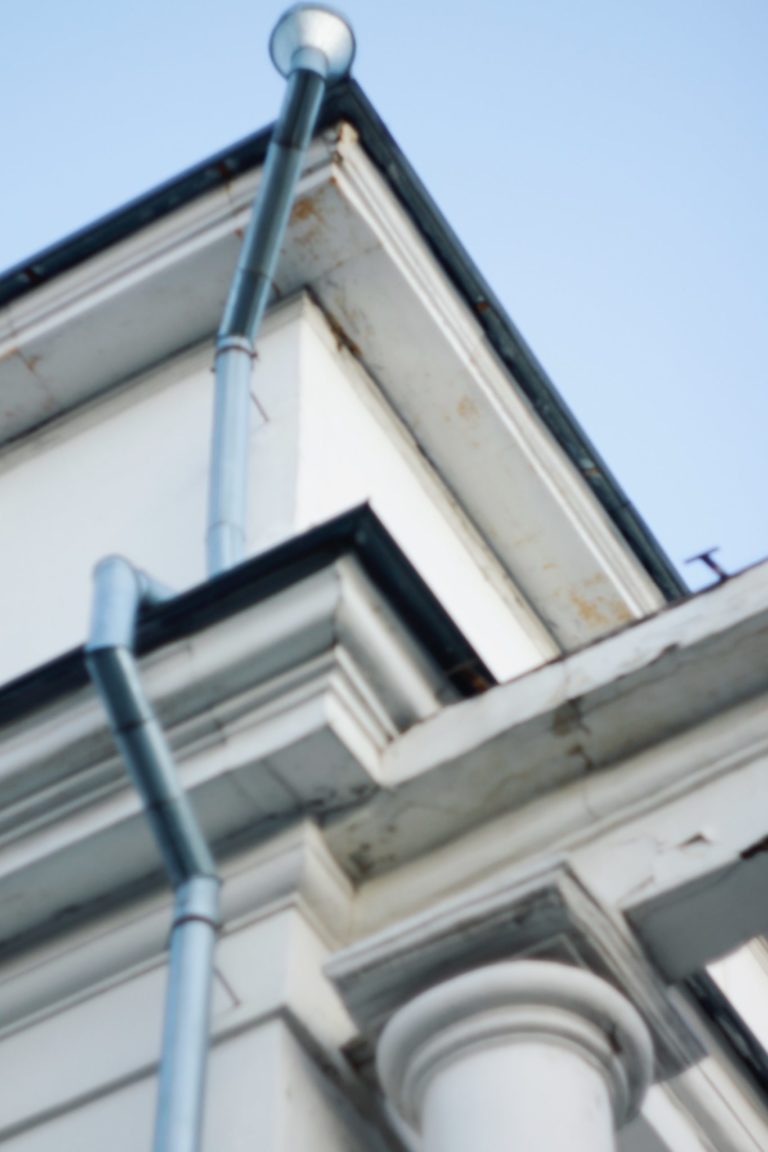 a white building with a metal pole