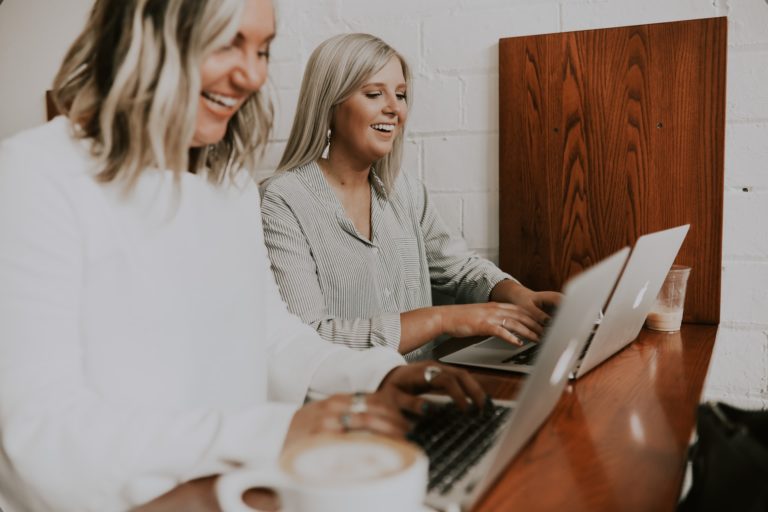 a woman and a man looking at a laptop