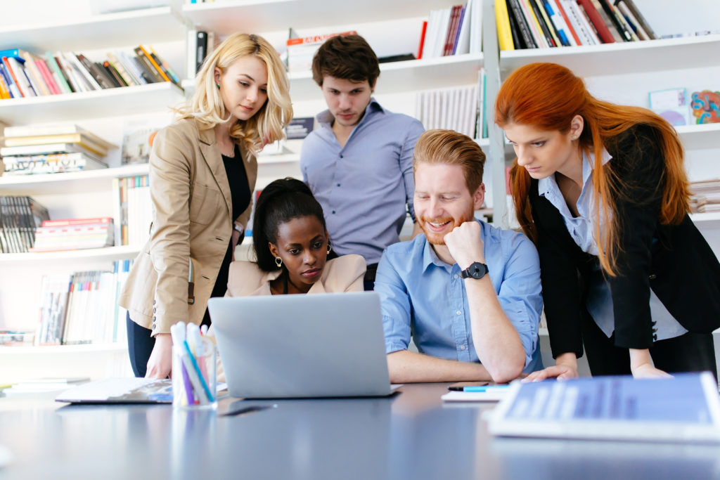 a group of people looking at a laptop