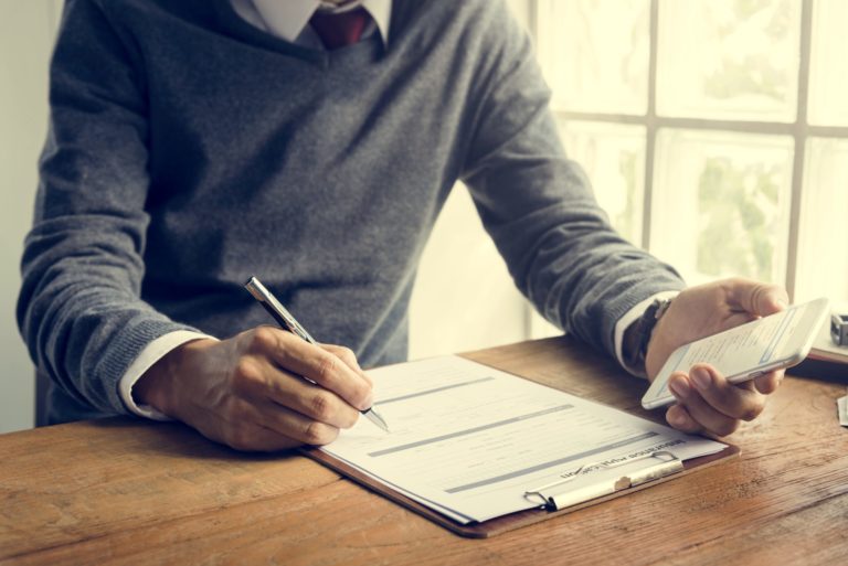 a man writing on a piece of paper